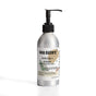A silver aluminum bottle with a black pump labeled Soap Distillery Hand + Body Wash sits on a white background. The 8 fl oz (236 mL) label notes scents of hinoki wood, smoke, and fern.