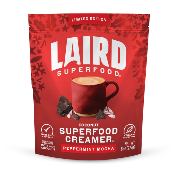 Laird Superfood Peppermint Mocha Superfood Creamer comes in a red pouch, pictured with a coffee mug, chocolate, and peppermint candies. This vegan creamer is packed with MCTs and is gluten-free and non-GMO.