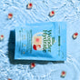 A blue package of Plant People WonderHydrate Electrolyte Gummies sits on rippling water, surrounded by red and white square gummies. The packaging promotes hydration, zero sugar, vegan, and gluten-free benefits.