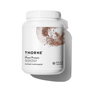 A white container of Thorne Plant Protein - 22g of Protein per Serving, a chocolate vegan supplement with a complete amino acid profile, displays abstract brown and black artwork on the label and casts a shadow on a white background.