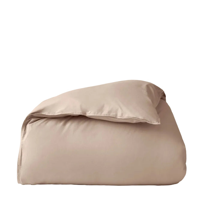 A neatly folded, light beige comforter sits against a plain white background, its texture reminiscent of the Coyuchi Organic Crinkled Percale™ Duvet Cover—perfect for pairing with this breathable bedding essential.