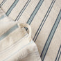 The Coyuchi Acacia Organic Hand Towel, Set of 2, features a cream-colored, highly absorbent design with blue and light gray textured stripes. A white fabric loop is sewn into one corner for easy hanging, and the towel is shown resting on a matching striped surface.