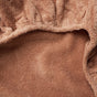 Close-up of the Cloud Loom™ Organic Changing Pad Cover by Coyuchi, highlighting its soft, light brown, fuzzy texture and gathered edge—showcasing the plush fabric’s subtle folds.