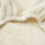 Close-up of a soft, cream-colored, fluffy surface with gentle folds and a plush texture, reminiscent of the Coyuchi Cloud Loom™ Organic Changing Pad Cover designed for a baby-safe changing pad.