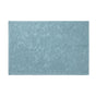 Coyuchi’s Wildflower Organic Bath Rug in light blue features a rectangular shape with an embossed floral pattern and textured surface, displayed against a white background.