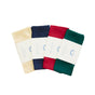 The Holiday Reusable Gift Wrap Furoshiki Set by Sarahs Silks features four folded bandanas in cream, navy blue, red, and green with “Mini Parisik” rainbow paper bands, perfect as sustainable gift wrapping, shown on a white background.