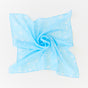 The Winter Wonderland Reusable Gift Wrap Furoshiki Set by Sarahs Silks features a light blue scarf with white snowflake patterns, laid flat and twisted on a white background—ideal for sustainable and elegant gift wrapping.