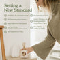 A person places an Enviroscent Stix Diffuser Air Freshener Starter Kit - Pet Odor Neutralizer onto a shelf next to a list of features titled Setting a New Standard, including no toxic contaminants, flames, soot, or spills.