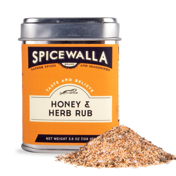 A Spicewalla Hot Honey BBQ Rub tin sits beside a small pile of the coarse, colorful, and spicy seasoning blend with sweet brown sugar notes, all displayed against a white background.