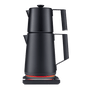 The SAKI Turkish Tea Maker Pro, a modern black electric kettle featuring a unique double-stacked pot design, sits on a base with an orange glowing ring. It offers convenient temperature control, making it perfect for preparing Turkish tea, and is photographed against a plain white background.