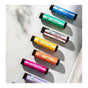 Seven vibrant tubes from the Savannah Bee Company’s Bee The Balm Lip Balm Gift Set are arranged diagonally on a light surface. Each beeswax lip balm features a distinct flavor label—Earl Grey, Mint Tulip, Honey Almond, Tupelo Honey, Peach, Wild Blackberry, and Rosemary Lavender—making this set a delightful gift for any occasion.