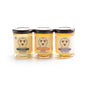 Three jars from the Savannah Bee Company Honey Artisanal Sampler Set—Acacia, Orange Blossom, and Lavender—stand side by side on a white background, each featuring a black lid and a rich golden-yellow hue.