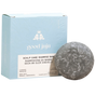 A round grey Scalp Care Conditioner Bar by Good Juju Body & Home sits before a light blue box with white lettering. Made with organic ingredients, it naturally conditions hair and helps relieve dandruff with lavender and geranium.