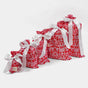 The Waste Free Celebrations Reusable Gift Bags Set includes four 100% cotton red and white fabric bags with festive patterns and white ribbon bows, arranged in a row from smallest to largest on a plain white background—offering a stylish and sustainable gift-wrapping solution for any occasion.
