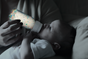 As part of Grove Co.'s Unplastic Your Life Educational Campaign, a baby is bottle-fed under moody lighting, gazing up at a bottle filled with colorful fragments resembling plastic—symbolizing the dangers of plastic pollution.
