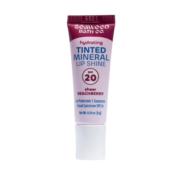 A tube of The Seaweed Bath Co Tinted Mineral Lip Shine SPF 20 in the shade Sheer Beachberry, featuring a white cap, stands upright against a white background. This hydrating mineral lip balm is enriched with organic Atlantic seaweed and shea butter to leave lips smooth and moisturized.