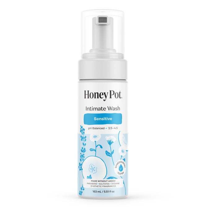 A white bottle of The Honeypot Company Foaming Wash - Sensitive with a pump dispenser and blue floral design, pH balanced, free of parabens and synthetic fragrances, featuring gentle lactic acid for sensitive skin.