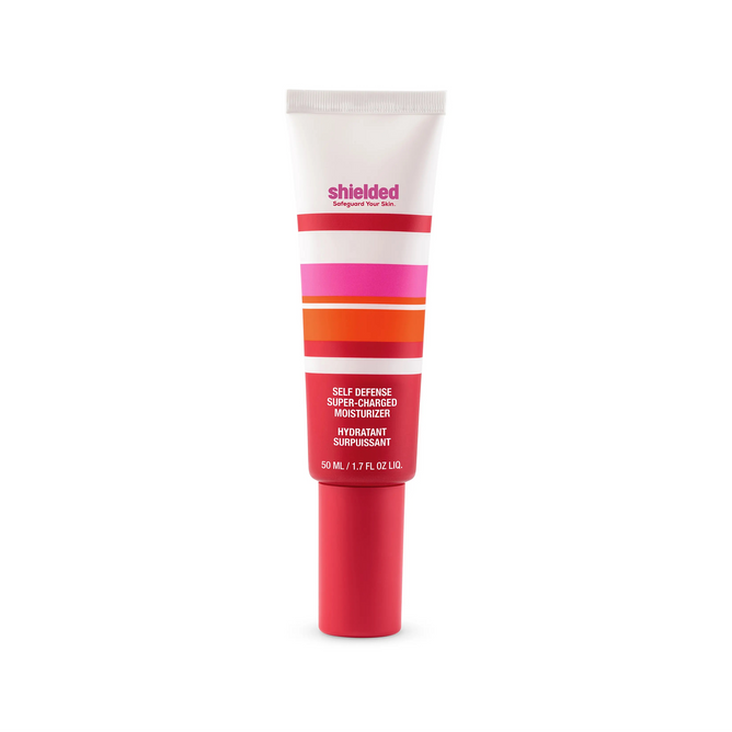 A tube of Shielded Beauty Self Defense Super-Charged Moisturizer, featuring pink, orange, red, and white stripes on its label, stands upright on a white background. This 50 mL (1.7 fl oz) moisturizer offers superior skin protection.