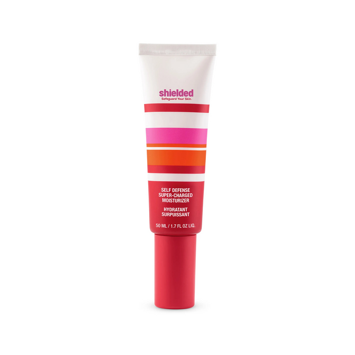 A tube of Shielded Beauty Self Defense Super-Charged Moisturizer, featuring pink, orange, red, and white stripes on its label, stands upright on a white background. This 50 mL (1.7 fl oz) moisturizer offers superior skin protection.