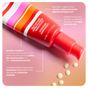 The Shielded Beauty Self Defense Super-Charged Moisturizer, in a vibrant tube with red, pink, and white stripes, sits on a pink surface. Key ingredients with antioxidants for the skin microbiome are highlighted, with cream droplets beside the tube.