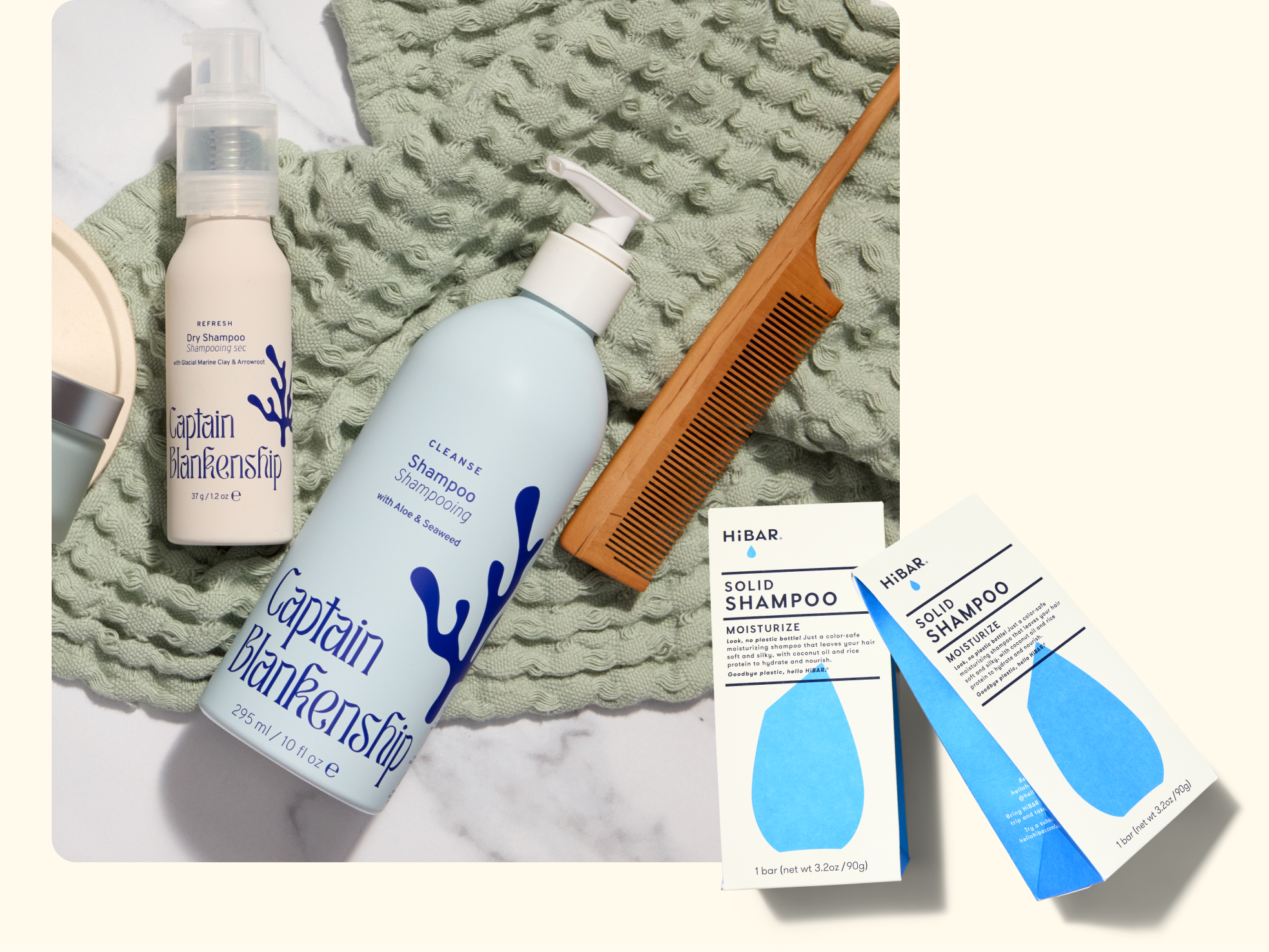 A bottle of Captain Blankenship shampoo, a dry shampoo spray, a wooden comb, a textured green towel, and two boxes of HiBAR solid shampoo displayed on a cream-colored surface.