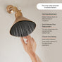 A person adjusts the Canopy Filtered Handheld Showerhead with water running, showing three adjustable streams. Features include easy tool-free attachment and quick filter replacement for healthier skin and hair.