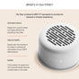 The Canopy Filtered Handheld Showerhead, shown in white, uses activated carbon, calcium sulfite, and KDF55 to remove chlorine and contaminants for healthier skin and hair.