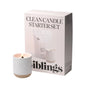 The Clean Candle Starter Set by Siblings includes a lit white candle in a minimalist Forever Vessel holder, beside a box labeled with the product name and featuring text and images of Siblings candles that describe their clean-burning properties and elevate your space with luxurious fragrance.