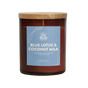The Signature Candle - Blue Lotus & Coconut Milk by Pacha Soap Co. is a brown glass jar with wooden lid, featuring notes of jasmine, blue lotus flower, and coconut milk. Crafted with soy, coconut, and apricot wax for a premium burn.