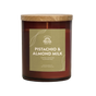 The Signature Candle - Pistachio & Almond Milk by Pacha Soap Co. comes in a brown glass jar with a wooden lid and green label, featuring a plant-based soy coconut apricot wax blend for a premium, clean burn.