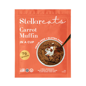 A red pouch of Stellar Eats Carrot Cake + Muffin In A Cup shows a baked muffin with cream and nuts, highlighting this grain-free, gluten-free mug cake snack with 7g protein.