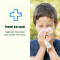 A young boy wipes his nose with a tissue. Text reads: How to use. Apply Plant Therapy Sniffle Stopper Roll-On - Pre-Diluted Essential Oil Blend to the chest and under the nose for respiratory support and to help clear congestion, next to a blue cross symbol.