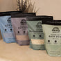 Pacha Soap Co. Sleep Epsom Salt Bath Soak, made with Epsom and sea salts, is shown on a light surface with dried lavender in the background. The bag features a calming design for a soothing bath experience.