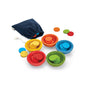PlanToys Sort & Count Cups Color Sorting Toys feature four wooden cups with matching discs in red, yellow, green, and blue. Extra discs and a navy drawstring bag make this sustainable set perfect for building early math skills.
