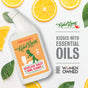 Rebel Green Toilet Bowl Cleaner sits among orange slices and green leaves. "Kissed with Essential Oils" text appears, plus Certified B Corporation and Women Owned logos, highlighting its eco-friendly commitment.