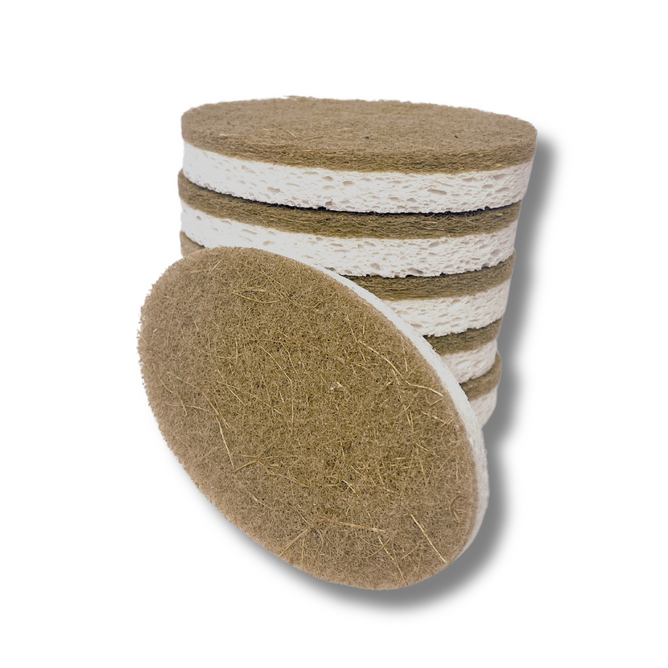 A stack of Scrub Be Love Oval Dish Sponges (6-Pack) with one sponge leaning against the pile. The brown and white plant-based pads have a rough, fibrous, eco-friendly texture. The background is white.