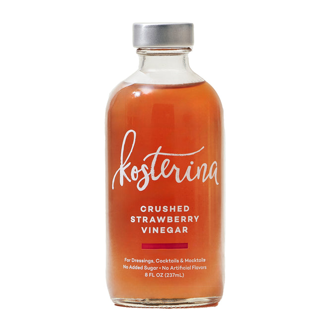 A clear glass bottle labeled Kosterina Crushed Strawberry Vinegar contains reddish liquid. The label says it’s great for dressings, cocktails, fruit salads, and mocktails, with no added sugar or artificial flavors. 8 fl oz (237 mL).