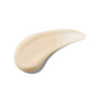 A smooth, beige-colored swatch of Ursa Major Sunny Start Eye Serum is spread in an arc shape on a white background, showcasing the texture and consistency of this de-puffing eye treatment.