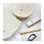 The SuperBee Beeswax Wrap Roll offers eco-friendly food storage with a hexagon pattern. Shown with its box and scissors on a light surface, it’s perfect for covering containers sustainably.
