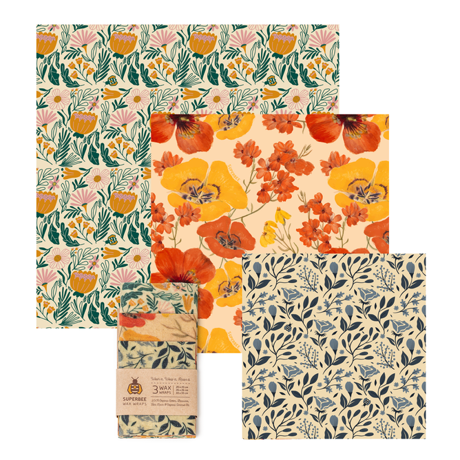 The SuperBee Essentials Beeswax Wraps set includes 3 square wax wraps with floral patterns in orange, yellow, blue, and green plus a rolled wrap with a paper label—stylish, reusable food storage that's plastic-free.