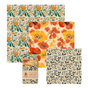 The SuperBee Essentials Beeswax Wraps set includes 3 square wax wraps with floral patterns in orange, yellow, blue, and green plus a rolled wrap with a paper label—stylish, reusable food storage that's plastic-free.