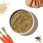 A bowl of The Honest Kitchen Dehydrated Whole Grain Chicken Dog Food (7 lbs box) is displayed on a white background, surrounded by oats, grilled chicken, carrots with greens, and parsley for a wholesome homemade look.