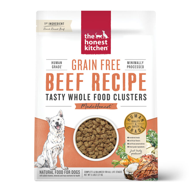 A bag of The Honest Kitchen Dry Dog Food, Grain Free Beef Whole Food Clusters features a dog illustration, images of beef and vegetables, and text highlighting Minimally Processed Whole Food Clusters and Natural Food for Dogs.