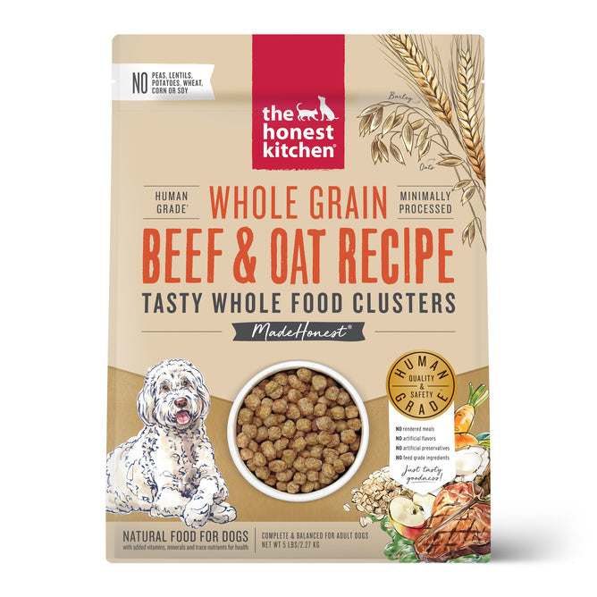 A beige bag of The Honest Kitchen Dry Dog Food, Whole Grain Beef & Oat Whole Food Clusters, with ranch raised beef, oats, veggies, a happy dog illustration, and a clear window showing the human grade food inside.