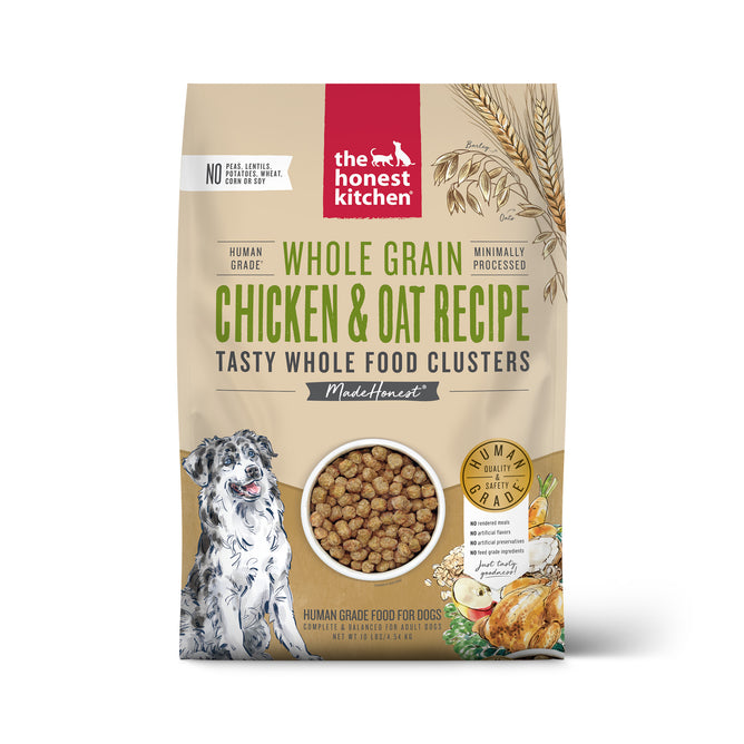 A beige bag of The Honest Kitchen Dry Dog Food, Whole Grain Chicken Whole Food Clusters, featuring illustrations of a happy dog, grains, chicken, and kibble. Highlights human grade, minimally processed whole food clusters.