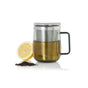 The AdHoc Borosilicate Glass Tea Mug with Stainless Steel Tea Infuser sits filled with tea beside a halved lemon and loose large-leaf teas on a white background.
