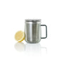 The AdHoc Borosilicate Glass Tea Mug with Stainless Steel Tea Infuser sits beside a halved lemon on a white background—perfect for brewing large-leaf teas.