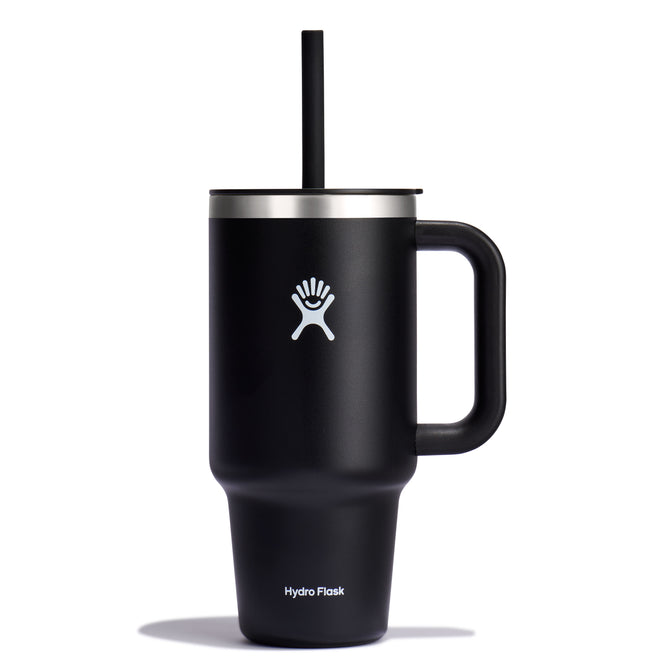 32 oz black insulated travel tumbler by Hydro Flask, featuring a handle, straw, white logo, and leak-resistant lid.
