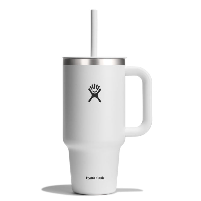 The Hydro Flask Travel Tumbler (32 oz) is a tall, white mug with a handle, silver rim, and straw featuring the brands logo. It has double-wall vacuum insulation for optimal temperature retention and a leak-resistant lid to keep your drink secure on any adventure.