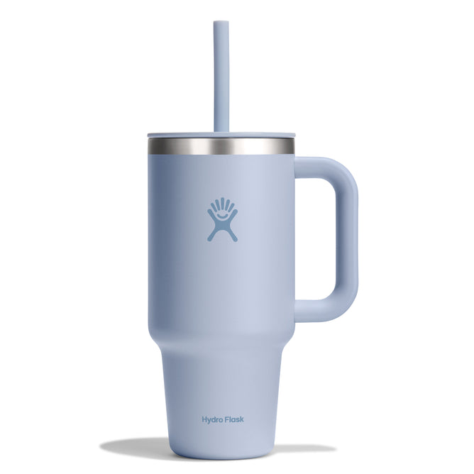 The 32 oz Travel Tumbler by Hydro Flask is a light blue insulated model featuring a handle, straw, and central logo. Its sleek design includes a stainless steel band for contrast and double-wall vacuum insulation to maintain your drinks temperature.